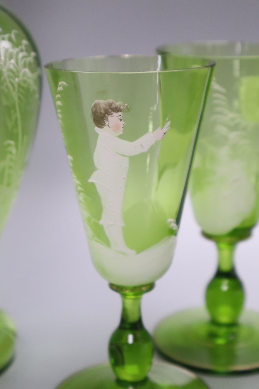 A Victorian Mary Gregory decorated green glass decanter, height 33cm and six tumblers